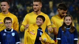 Cine este pu?tiul îmbr?cat de Bîrligea la intonarea imnului României, pe vremea câinoas? de la meciul cu San Marino